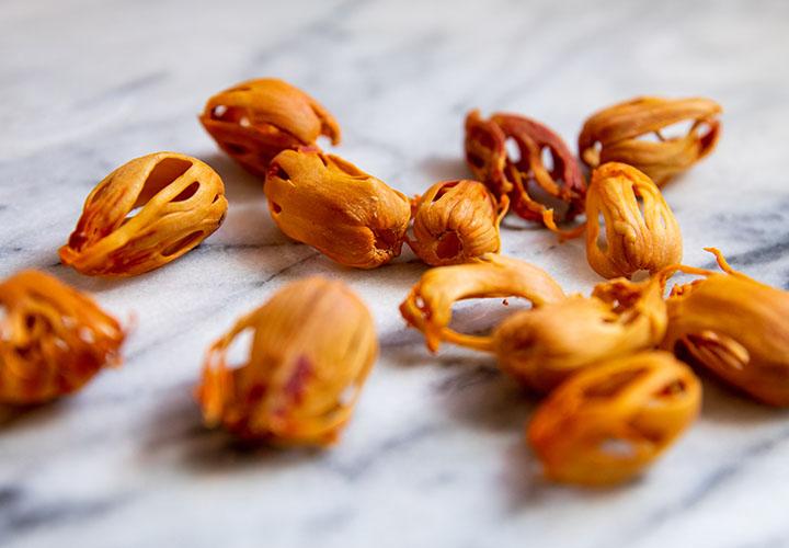 Whole Blade Mace spice on a beautiful white marble kitchen countertop.